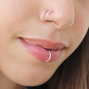 Nose and lip piercing on same side top