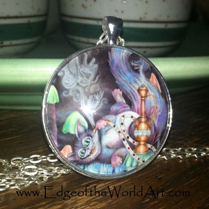 May include: A silver necklace with a round pendant featuring a whimsical illustration of a purple cat smoking a hookah. The cat has green eyes and a mischievous grin. The pendant is surrounded by a silver frame.