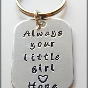 Puede incluir: Llavero de plata con un coraz&oacute;n y el texto "Always your little girl Hope".