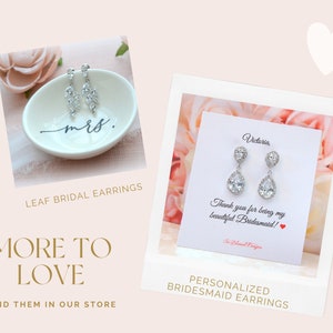 May include: Two pairs of silver bridal earrings with clear crystal stones. The earrings on the left are leaf-shaped and the earrings on the right are teardrop-shaped. The teardrop earrings have a personalized card with the text "Victoria" and "Thank you for being my beautiful Bridesmaid!"