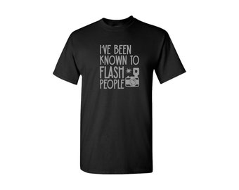 May include: Black t-shirt with a gray graphic that says "I've been known to flash people" with a camera icon.