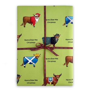May include: Green wrapping paper with a repeating pattern of Highland cows dressed in various festive outfits, including Santa Claus, a kilt, and a Scottish flag. The text "Have a Braw Wee Christmas" is repeated throughout the paper.
