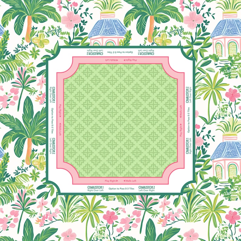 A decorative mah jongg mat with a tropical floral design. The background features palm trees, pink flowers, and small blue-roofed buildings. A central square with a green geometric pattern is framed in pink, with text that reads "Charleston".