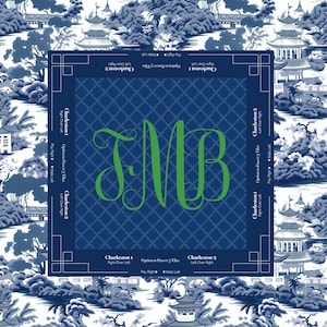 A square, navy blue mah jongg game board with a green monogram of the letters TMB. The board is surrounded by a blue and white Asian-inspired landscape design. The text "Charleston 1" and "Charleston 2" is printed on the board.