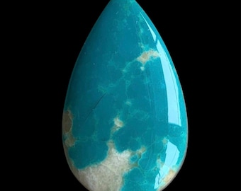 Puede incluir: Una piedra preciosa de turquesa pulida en forma de lágrima, con un color azul cian vibrante y patrones naturales de matriz blanca y gris claro en toda la superficie, mostrando un acabado suave y reflectante.