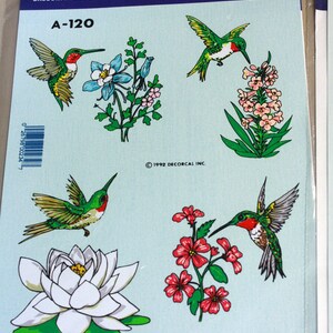 Puede incluir: Una hoja de pegatinas con dise&ntilde;os de colibr&iacute;es y flores pintados a mano. Las pegatinas est&aacute;n etiquetadas como "A-120" y "DECALS by Decorcal".