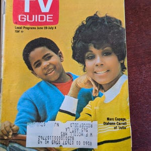 May include: A vintage TV Guide magazine cover featuring a young boy and a woman. The magazine has a yellow background with the title "TV GUIDE" in a red box. The cover also includes the text "Stalking A Rare Species - The TV Guest".