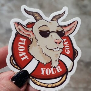 May include: A white goat wearing sunglasses is holding a red life preserver with the text "FLOAT YOUR GOAT" on it.