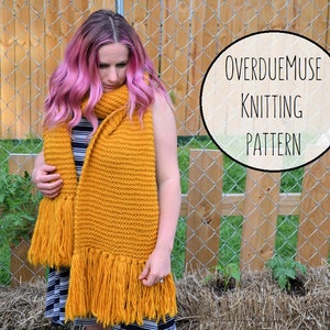 May include: A woman wearing a mustard yellow knitted scarf with long fringe. The scarf is draped around her neck and the fringe hangs down to her waist. The text "OverdueMuse Knitting Pattern" is visible in the image.