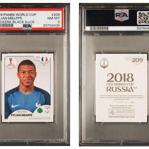 Könnte beinhalten: Ein Panini World Cup Sticker mit Kylian Mbappé in blauem Trikot, bewertet von PSA. Der Sticker ist in einer transparenten Schutzhülle. Die Rückseite zeigt das Logo der FIFA Fussball-Weltmeisterschaft Russland 2018.