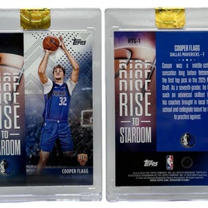 May include: A Topps trading card featuring Cooper Flagg of the Dallas Mavericks. The front shows Flagg in a blue jersey with the number 32, shooting a basketball. The card is labeled "Rise to Stardom."