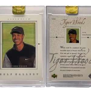 Puede incluir: Una tarjeta coleccionable de Tiger Woods Upper Deck Golf Gallery, en un estuche protector. La parte delantera presenta un retrato sonriente de Tiger Woods. La parte trasera tiene una imagen más pequeña de Woods y texto sobre su impacto en el golf.
