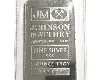 May include: A silver bullion bar with the inscription "JM Johnson Matthey Assayers & Refiners Fine Silver 999 1 Ounce Troy 357596" in a clear plastic protective case.