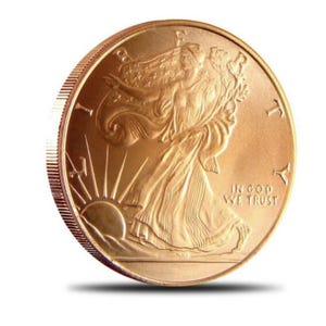 May include: A gold-coloured American Eagle coin with the inscription "In God We Trust" and a depiction of Lady Liberty.