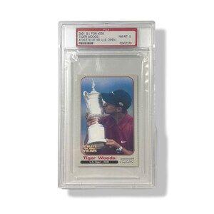 Könnte beinhalten: Eine Sammelkarte mit Tiger Woods, einem professionellen Golfer, der eine Trophäe hält. Die Karte stammt aus der Serie 2001 SI for Kids und trägt den Text "Athlete of the Year" und "U.S. Open 2000".