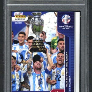 May include: A graded Panini Instant trading card featuring Lionel Messi. The card commemorates the 2024 Copa America victory, showing Messi holding the trophy with teammates. The card is graded GEM-MT 10 by Golden Grading, with the text "Another Final Hurrah for Messi".