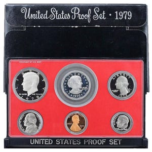 Op de afbeelding: Een 1979 United States Proof Set in een zwarte en rode doos. De set bevat een halve dollar, een kwart, een dime, een nikkel en een penny.