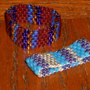 May include: Two beaded rings, one with red, blue, and purple beads, and the other with blue, purple, and white beads.
