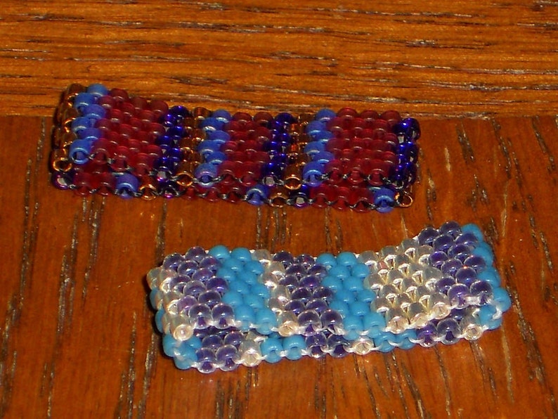 May include: Two beaded bracelets, one with red, blue, and gold beads, and the other with blue, white, and purple beads.