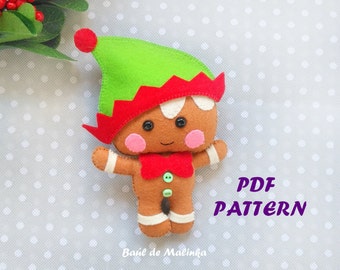 May include: A gingerbread man elf plush toy pattern. The pattern is for a gingerbread man with a green hat and red trim, brown eyes, pink cheeks, and a red bow tie. The pattern includes the text "PDF PATTERN".