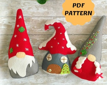 May include: Three felt gnome ornaments, one with a red hat and white beard, one with a red and white house hat, and one with a gray hat and red beard. The ornaments are on a white wooden background with a red berry branch and a yellow circle with the text "PDF PATTERN".
