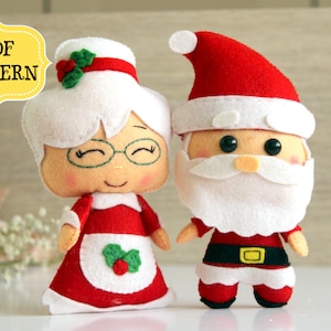May include: Felt Christmas ornaments of Santa Claus and Mrs. Claus. Santa wears a red hat and suit with a white beard. Mrs. Claus wears a red dress and white apron. The ornaments are handmade and have the text "PDF PATTERN".