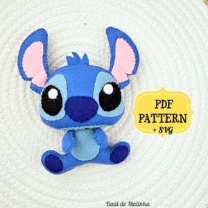 May include: Blue felt Stitch character plush toy with large eyes and pink ears. PDF PATTERN + SVG text is on a yellow label.
