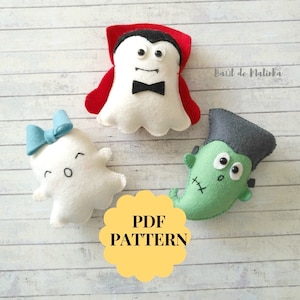 May include: A collection of handmade felt Halloween decorations. The set includes a white ghost with a blue bow, a vampire with a red cape, and a green Frankenstein's monster. The image also includes a yellow PDF pattern graphic.