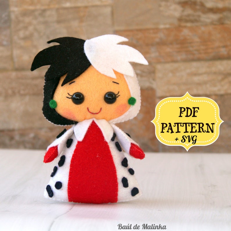 May include: A felt doll of Cruella de Vil from Disney's 101 Dalmatians. The doll is wearing a red and white dress with black spots. The doll has black and white hair and green earrings. The image also includes the text "PDF PATTERN + SVG".