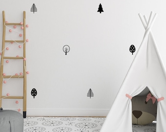 May include: A child's playroom with a white teepee, a wooden ladder with pink string lights, and a gray beanbag. Black tree decals decorate the white wall. The floor has a black and white patterned rug.