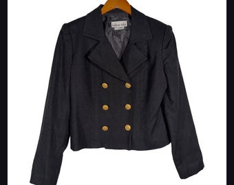 May include: A black double-breasted blazer featuring a notched lapel, long sleeves, and six gold-toned buttons arranged in two vertical rows. The interior label displays the text Hélène Sidel. The garment is displayed on a wooden hanger.