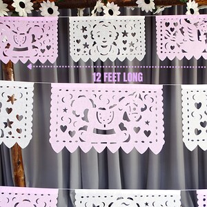 May include: A pink and white paper banner with cut-out designs, including a rocking horse, stars, and hearts. The banner is 12 feet long.