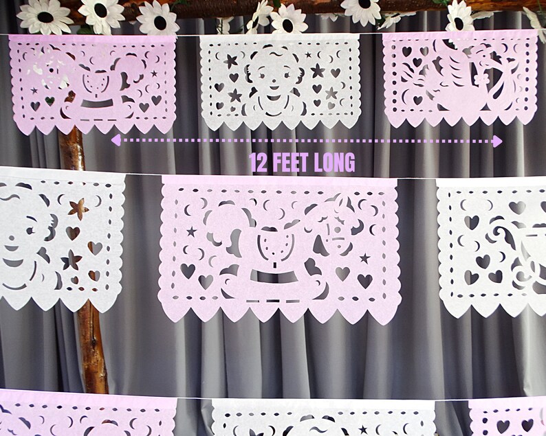 May include: A pink and white paper banner with cut-out designs, including a rocking horse, stars, and hearts. The banner is 12 feet long.
