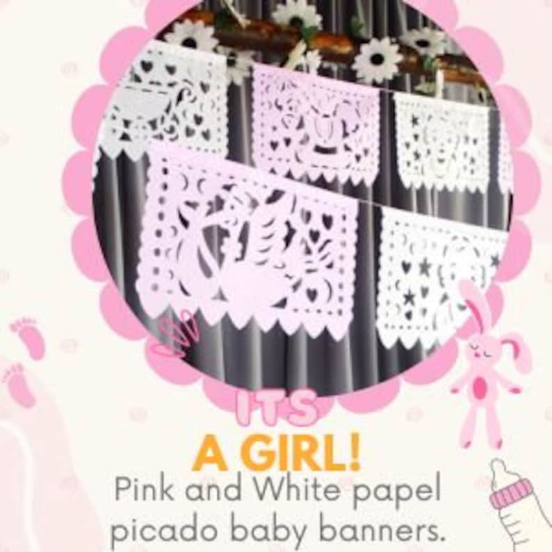 May include: Pink and white paper picado banners with the words "It's a Girl!" hanging from a string. The banners are decorated with cut-out designs of a baby carriage, stars, and other baby-related motifs.