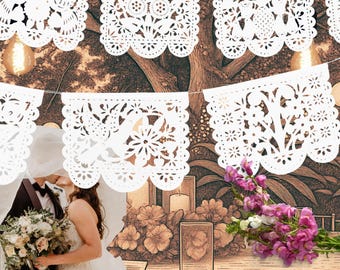 May include: A white paper banner featuring intricate cut-out designs of birds, flowers, and foliage. The rectangular panels are suspended on a thin string, each displaying unique patterns with scalloped edges, creating a decorative garland.