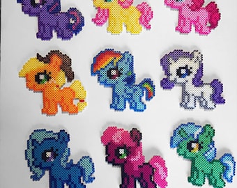 以下が含まれることがあります： パーラービーズで作ったカラフルなポニーのフィギュア9体。ポニーは様々なポーズで、たてがみと尻尾の色がそれぞれ違います。