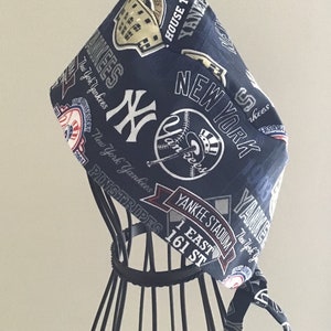 May include: A blue and white patterned surgical scrub hat with the New York Yankees logo and text, including "Yankee Stadium", "1 East 161 St", and "Pinstripes".
