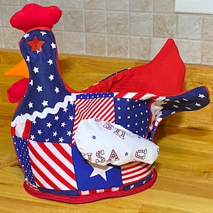 May include: A red, white, and blue patchwork fabric chicken with a red comb and a white wing with the word "USA" printed on it.