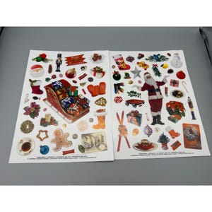 May include: Two sheets of Christmas-themed stickers with various festive images. The stickers include Santa Claus, a sleigh filled with gifts, stockings, ornaments, and a gingerbread man. The color palette is red, green, white, and gold.