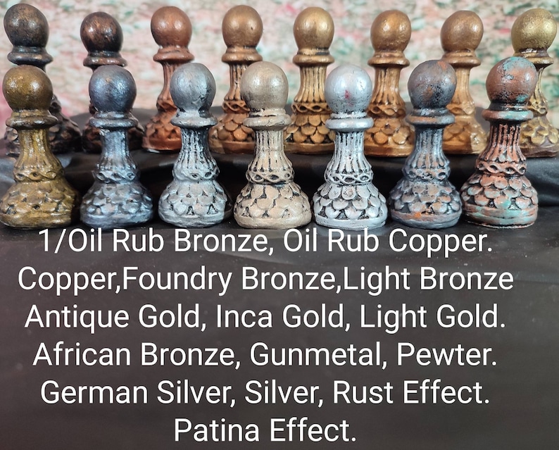 May include: A collection of 12 small decorative chess pieces in various metallic finishes, including oil rubbed bronze, copper, foundry bronze, light bronze, antique gold, inca gold, light gold, African bronze, gunmetal, pewter, German silver, silver, rust effect, and patina effect.