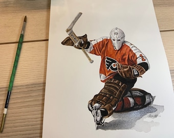 May include: Watercolour painting of a hockey goalie wearing an orange and black uniform with a white helmet and a black and white stick. The goalie is in a kneeling position with the stick raised in the air. The painting is signed in the bottom right corner.