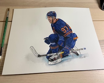 May include: A watercolor painting of a hockey player in a blue and orange uniform, skating and holding a hockey stick. The player is wearing a helmet and has a determined expression on their face. The painting is signed "Shay Hay" in the bottom right corner.