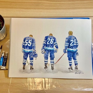 May include: Watercolour painting of three hockey players wearing blue and white jerseys with their numbers on the back. The players are facing away from the viewer and are standing on a white background. The painting is signed "Drew 3/2 20".