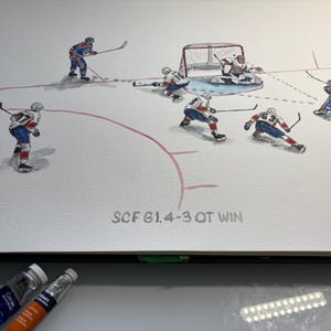 May include: Watercolour painting depicting a hockey match. Players in blue and white uniforms are shown on the ice, with a net in the background. The text "SCF G1.4-3 OT WIN" is visible. Paint tubes and a paintbrush are in the foreground.