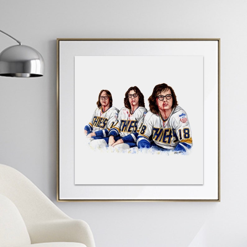 May include: A watercolor painting of three men wearing hockey jerseys with blood splatters on their faces. The jerseys are white with blue and gold accents and the text "Blues 18" on the front.