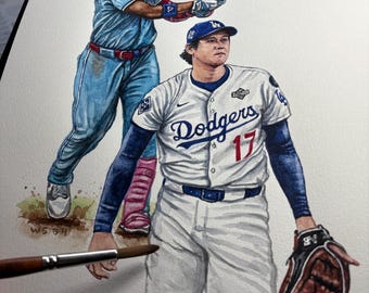 Puede incluir: Pintura a la acuarela de dos jugadores de béisbol de los Dodgers de Los Ángeles. Uno está bateando, el otro es un lanzador que lleva una camiseta de los Dodgers con el número 17. La obra está firmada y fechada.