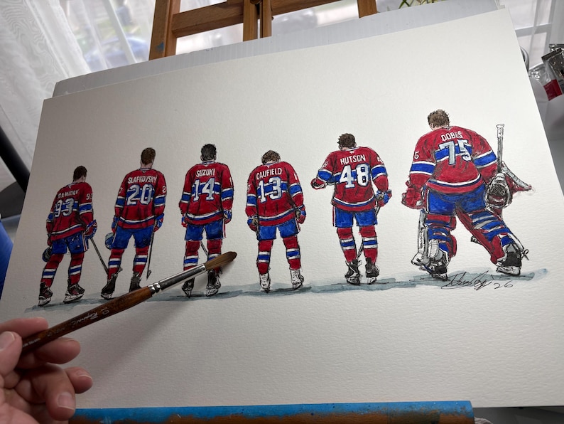 Puede incluir: Pintura a la acuarela de un equipo de hockey sobre hielo con uniformes rojos, blancos y azules. Los jugadores se ven por la espalda, con sus n&uacute;meros y apellidos visibles. Tambi&eacute;n se representa a un portero. La obra est&aacute; sobre papel blanco.