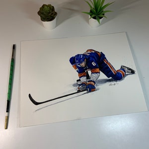 May include: Watercolor painting of a hockey player in a blue and orange uniform, wearing a helmet and holding a hockey stick. The player is in a dynamic pose, with one leg extended and the other bent. The background is white with a few splashes of gray paint.