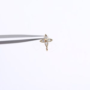 May include: A gold-toned flower charm with clear cubic zirconia stones. The charm has a loop at the bottom for attaching to a bracelet or necklace.