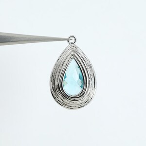 1126052 / Aigue-marine / Pendentif en verre avec cadre en laiton plaqué rhodium 13,4 mm x 21,3 mm / 2,7 g / 2 pièces